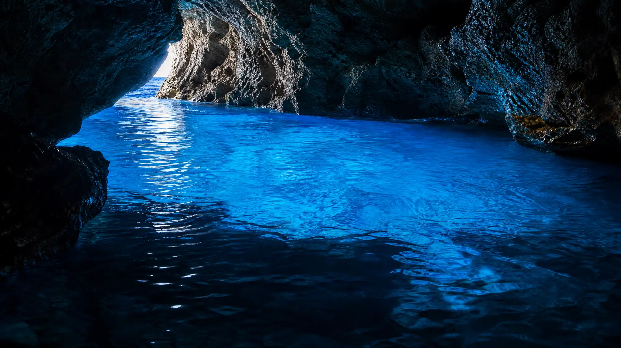 Erkunden Sie die berühmte 30 Meter lange Meereshöhle am Kap Maeda. Das Sonnenlicht wird vom weißen Kalksteinboden reflektiert und erzeugt einen leuchtend blauen Schein.