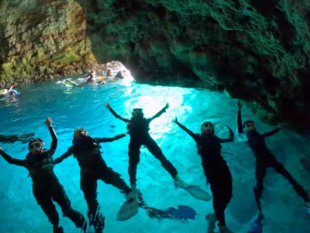 Gruppe von Schnorchlern, die im Kreis in der hellen Blauen Grotte treiben