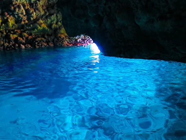 Blaue Grotte in Okinawa mit leuchtend blauem Wasser und felsigen Grottenwänden