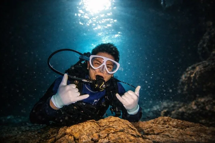 Group of scuba divers in the water preparing to descend