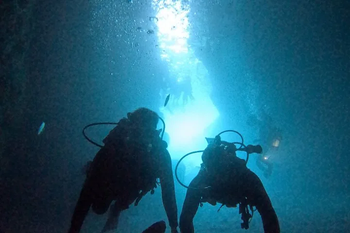 Paar beim Schnorcheln unter Wasser, das Hand in Hand ein Herz formt